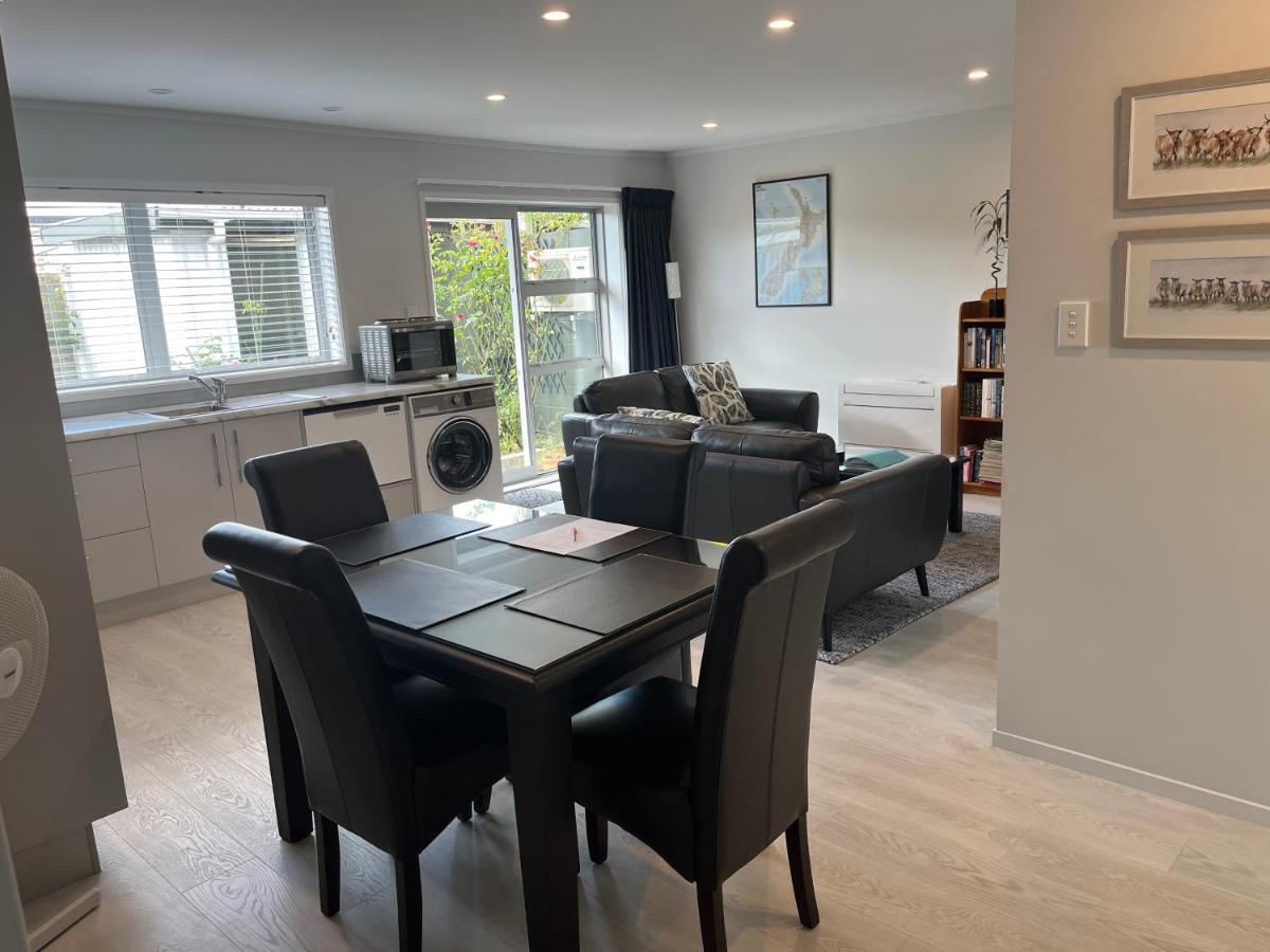 The open-plan dining and lounge area with kitchenette and garden outlook